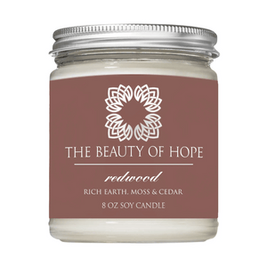 Redwood 8oz Candle | The Beauty of Hope soy candle with a scent blend of rich earth, moss, and cedar in a clear glass jar with a silver lid.