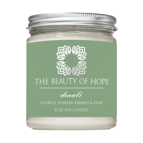 Denali 8oz Candle | The Beauty of Hope with cypress, juniper berries, and pine scent in a clear glass jar with a silver lid, designed for wellness and relaxation.