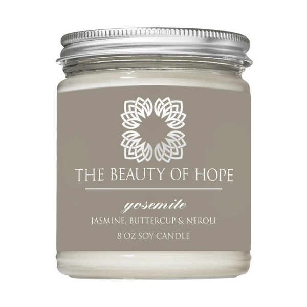 Yosemite 8oz Candle | The Beauty of Hope featuring a glass jar with a metal lid, labeled with jasmine, buttercup, and neroli scent for a calming and uplifting ambiance.