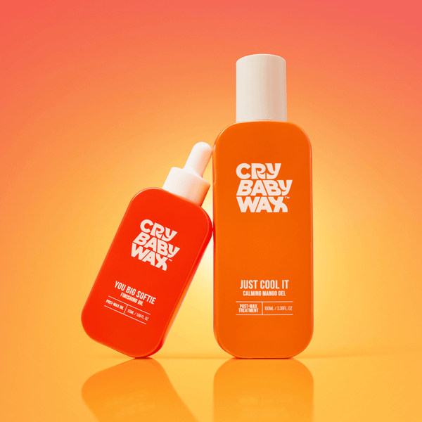 Two vibrant orange bottles of Crybaby Wax products against a warm gradient background, featuring You Big Softie Finishing Oil | Crybaby Wax and Just Cool It calming mango gel for skincare and body care wellness.