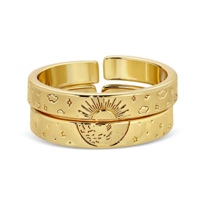 Stacked gold rings with engraved celestial designs including the sun, moon, stars, and clouds, styled in a modern open band format, Celestial Rings | Meghan Bo.