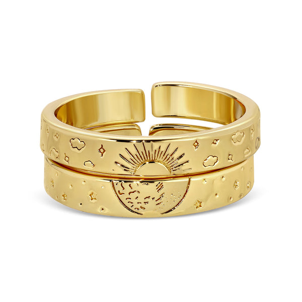 Stacked gold rings with engraved celestial designs including the sun, moon, stars, and clouds, styled in a modern open band format, Celestial Rings | Meghan Bo.