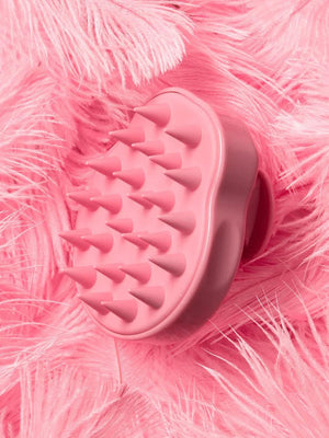 Soft pink Scalp Scrubber [Revitalizing Scalp Massager] | Dreambox Beauty with flexible silicone bristles resting on delicate pink feathers for a soothing wellness experience.