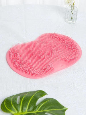 Pink silicone scrubber with soft bristles designed for exfoliating back and feet, promoting skincare and body care wellness with the Back & Foot Scrubber | Dreambox Beauty.