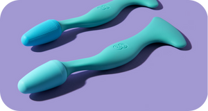 Two turquoise wellness devices with ergonomic handles designed for facial care and massage, shown on a purple background, featuring the Face Roller | RAD.