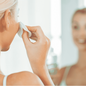 Person using a cotton pad to apply Gentle Mineral Toner - Infused w/ Rose Quartz | Privai on their face, reflecting a skincare routine focused on wellness and self-care.