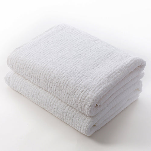 Two neatly folded white towels made from soft, absorbent material, highlighting the plush texture and quality of the Hotel Collection Organic Cotton | TOWL.