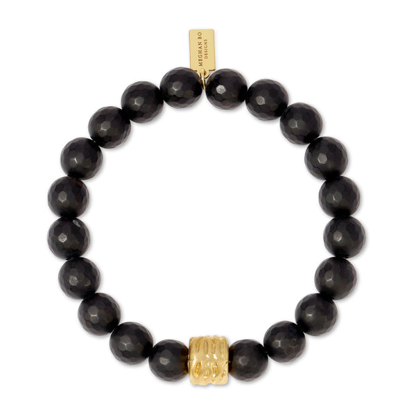 Matte Black Beaded Stretch Bracelet | Meghan Bo featuring faceted black beads with a textured gold accent bead and a small gold tag on a stretchy band.