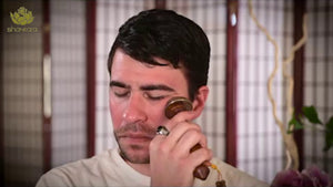 Man using Kansa Wand Face | Shankara for facial massage in a calm wellness setting promoting skincare and relaxation.