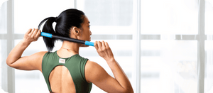 Person using Rod Mini | RAD in a teal color for muscle recovery and wellness, holding the device behind their back in a bright indoor space.