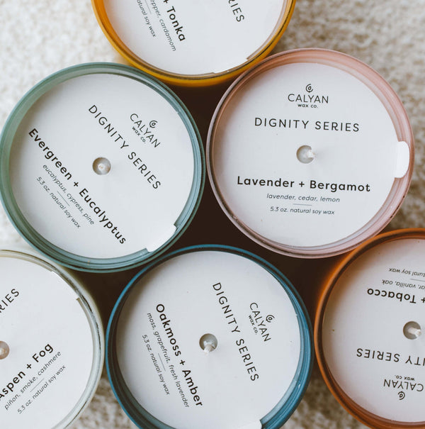Oakmoss + Amber Dignity Series Glass Jar Soy Candle | Calyan Wax Co. - 5.3 oz displayed among other scented candles from the Dignity Series collection.
