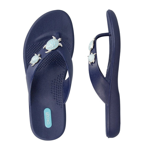 Theresa | Oka-B navy blue flip-flops with textured footbed and decorative light blue turtle accents on the straps designed for comfort and casual wear.