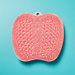 Back & Foot Scrubber | Dreambox Beauty in coral color with soft silicone bristles designed for effective skincare and body care, placed on a blue background.