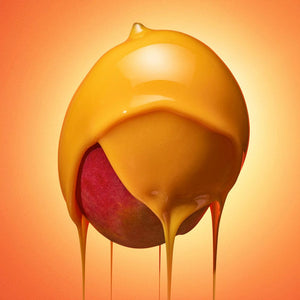 Close-up of red fruit covered in smooth golden wax dripping, representing Full On Meltdown Vegan Hard Wax | Crybaby Wax for skincare and body care use.