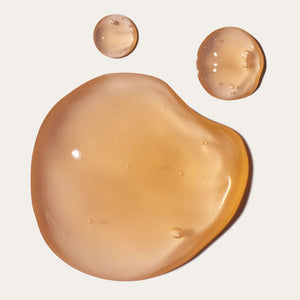 Close-up of smooth, translucent mango-colored gel droplets showcasing the texture of Just Cool It Calming Mango Gel | Crybaby Wax, a soothing skincare product.