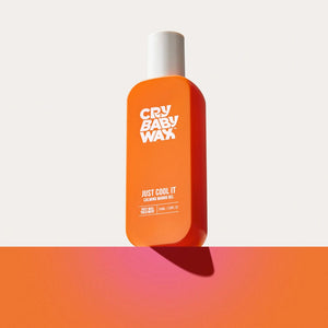 Bright orange bottle of Just Cool It Calming Mango Gel | Crybaby Wax with white cap, designed for skincare and body care, casting a soft shadow on an orange surface.