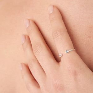 Close-up of a hand wearing a delicate white ring with two small clear stones, showcasing the Jelly Tots Ring | Little Sparkles design.