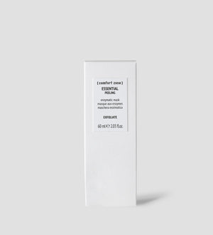 Minimalist white packaging of Essential Peeling | [ comfort zone ], an enzymatic mask for exfoliating skincare, displayed against a light gray background for a clean wellness aesthetic.