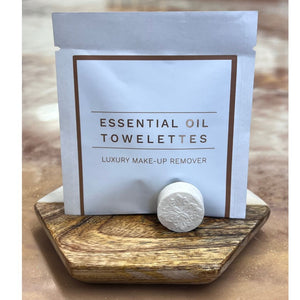 Package of Essential Oil Towelettes luxury make-up remover displayed on wooden tray with a single embossed wipe, promoting Make Up Remover Wipes | Functional Botanicals for skincare.