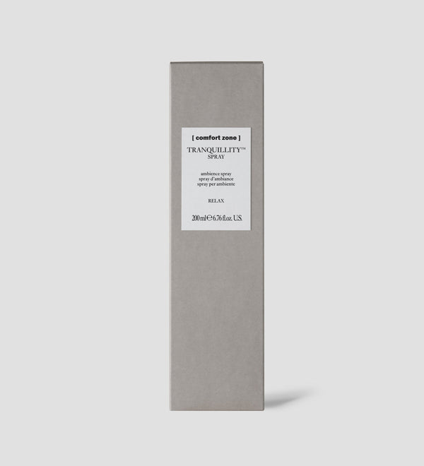 Minimalist gray rectangular box packaging for Tranquillity Spray | [ comfort zone ] with a white label featuring simple black text on a plain light gray background.