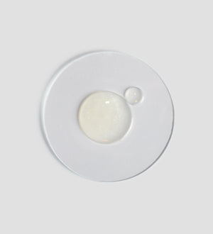 Clear and transparent gel drops on a white surface, representing the texture of Active Pureness Gel | [ comfort zone ] skincare product.
