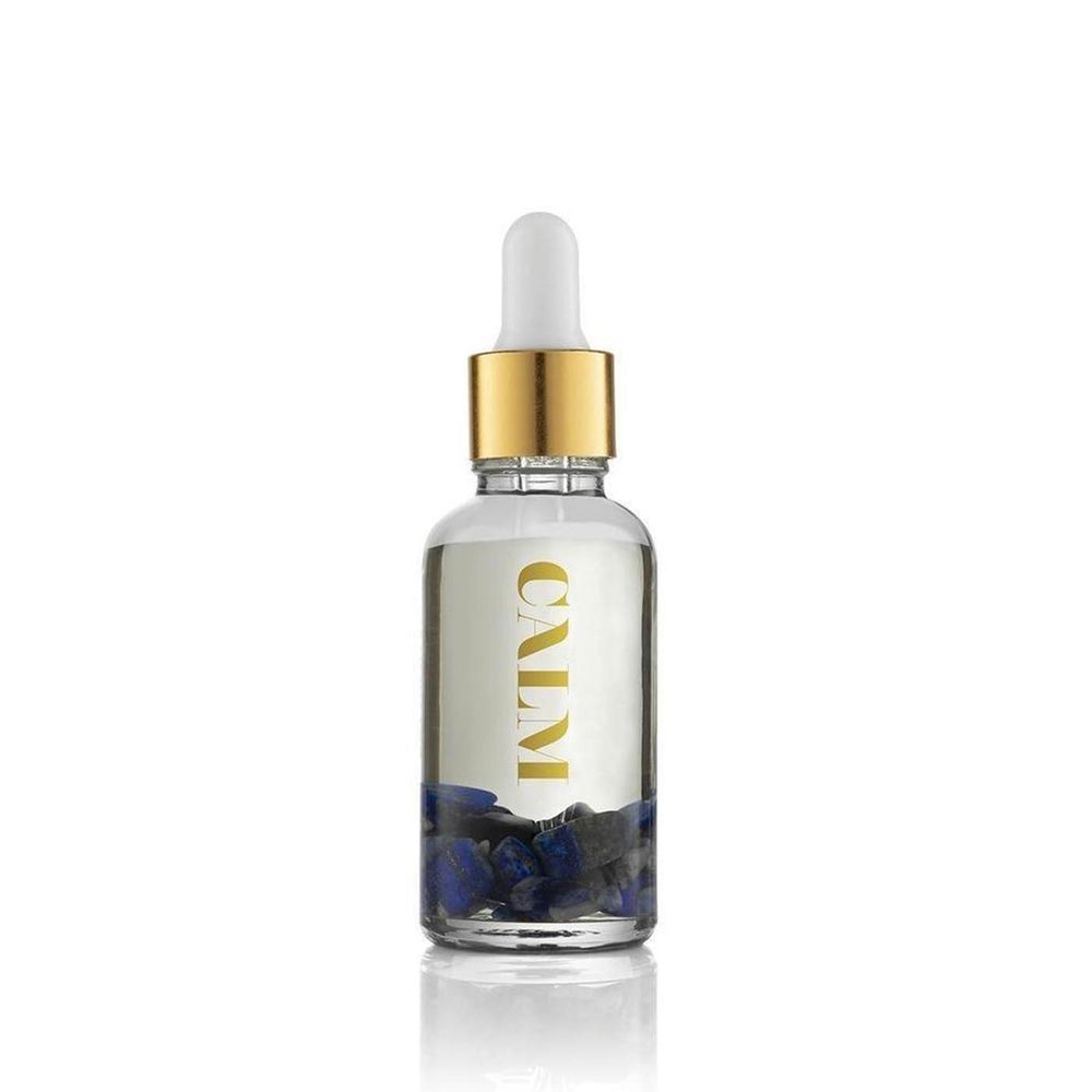 Calm Essential Oil Vial | Aluminate Life featuring a clear glass dropper bottle with blue sodalite crystals inside and a branded white and gold cylindrical packaging for wellness and skincare.