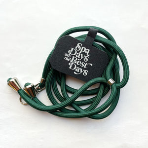 Crossbody Phone Lanyard With Adjustable Strap | Live Love Spa in dark green with silver accents, featuring a tag that says "Spa Days are the Best Days" for skincare and wellness convenience.