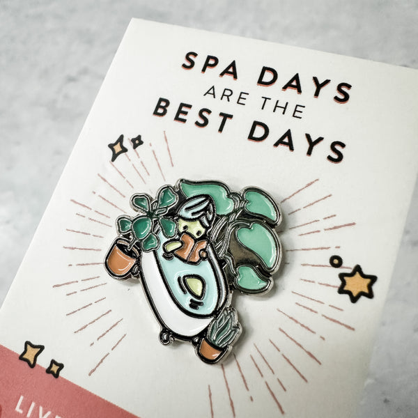 Fab Spa Life Enamel Pin - Limited Edition | Lucky Owl depicting a relaxing bathtub scene with plants and spa elements, emphasizing wellness and self-care.