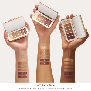 Three arms with different skin tones showing swatches of six neutral shades from the Purepressed Eye Shadow Palette | Jane Iredale, held next to the palette cases with mirrors.