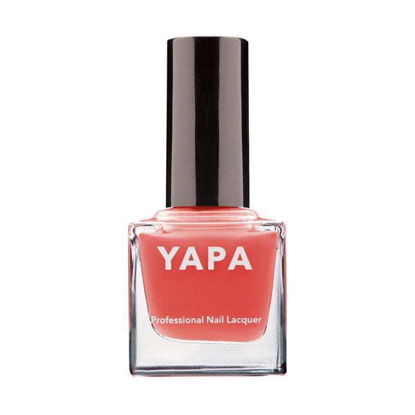 A bottle of Freya Nail Lacquer | YAPA in a coral shade with a sleek black cap, designed for professional nail application and beauty care.