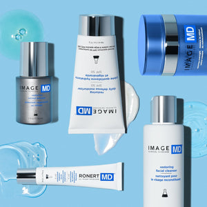 Restoring Daily Defense Moisturizer SPF 50 | IMAGE Skincare tube on blue background surrounded by related skincare products and moisturizer textures.