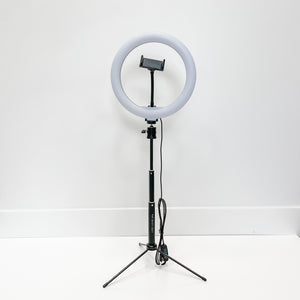 Ring Light - 10" standing on a black tripod with adjustable height and a phone holder in the center, suitable for skincare and wellness content creation.