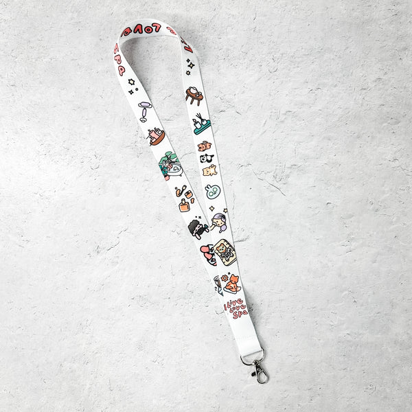 Lanyard - Fab Spa Life Characters | Lucky Owl featuring colorful cartoon-style spa and wellness icons on a white background with a metal clip attachment.