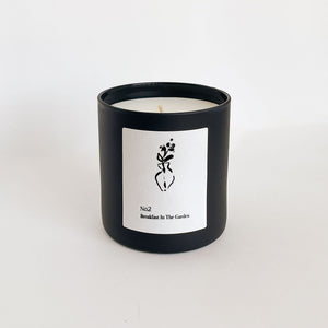 Minimalist black candle container with a white label featuring a simple floral illustration, presenting the No. 2 Breakfast In The Garden (Swiss Alps) Candle | Lucky Owl.