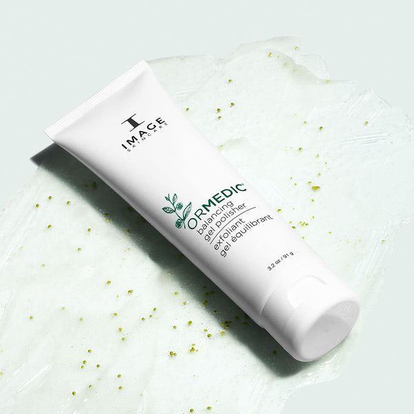 ORMEDIC balancing gel polisher | IMAGE Skincare tube on a textured natural gel background with green exfoliating particles for gentle skincare exfoliation.