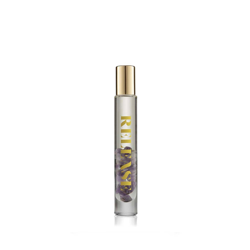 Release Essential Oil Rollerball | Aluminate Life with amethyst crystals inside a clear glass bottle and a gold cap, accompanied by its decorative white and purple cylindrical packaging.