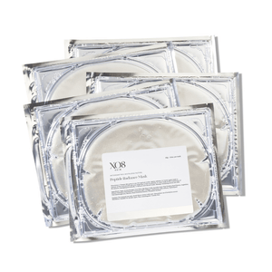 Four silver foil packets of Peptide Radiance Mask | XO8 Cosmeceuticals stacked, highlighting packaging design for skincare and wellness use.