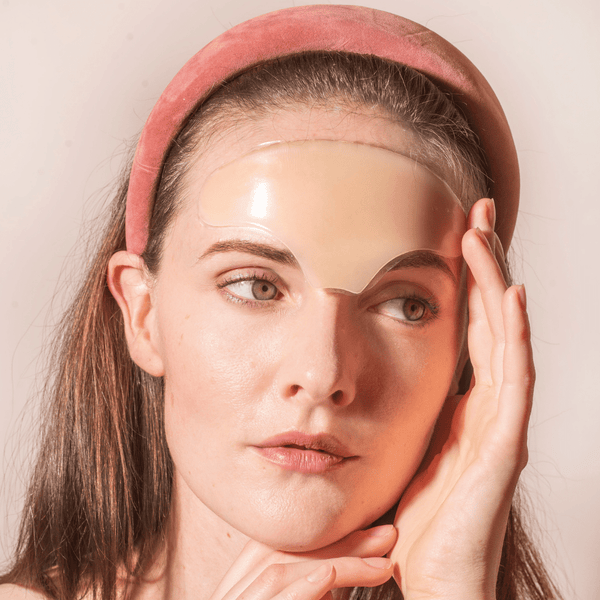 Woman wearing a clear Skin Plumping Reusable Forehead Pad | Dreambox Beauty on her forehead, showcasing a skincare tool designed for hydration and smoothing fine lines.