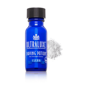 Blue glass bottle of Drying Potion | Ultraluxe Skincare with black cap, accompanied by a small pile of white powder on a white background.