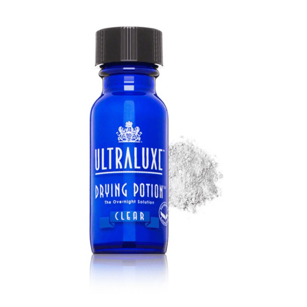 Blue glass bottle of Drying Potion | Ultraluxe Skincare with black cap, accompanied by a small pile of white powder on a white background.