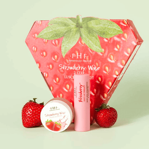 Strawberry Wine 2-Step Luscious Lip Kit | FarmHouse Fresh displayed with strawberry-themed packaging, lip balm, and lip scrub alongside fresh strawberries, highlighting skincare and wellness.