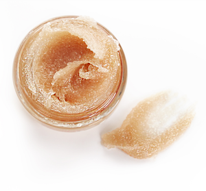 Open jar of Whoopie® Lip Polish | Farmhouse Fresh showing smooth, exfoliating lip scrub texture in light brown color with a small amount swiped beside it.