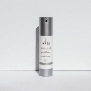 Bottle of AGELESS total anti-aging serum | IMAGE Skincare standing upright with a silver cap and white label on a plain white background, showcasing skincare product design.