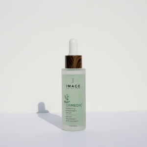 ORMEDIC balancing antioxidant serum | IMAGE Skincare in a frosted glass bottle with a white dropper and wood-textured collar, designed for skincare and wellness.