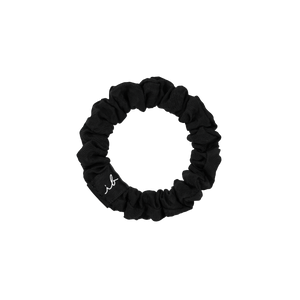 Black fabric scrunchie hair tie with a small white embroidered script detail, part of the LOOP 3 pc | invisibobble collection for gentle, stylish hair care.