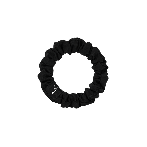 Black fabric scrunchie hair tie with a small white embroidered script detail, part of the LOOP 3 pc | invisibobble collection for gentle, stylish hair care.