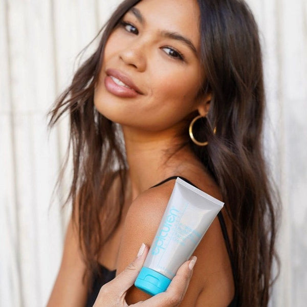 Smiling woman with glowing skin holding a tube of Acidophilus Probiotic Facial Cream | Epicuren Discovery, showcasing skincare for healthy, radiant complexion.