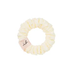 Cream-colored fabric hair scrunchie with a small "ib" tag, part of the LOOP 3 pc | invisibobble collection designed for gentle hair care and stylish wellness accessory.