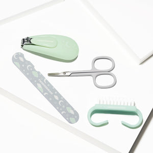 Baby Manicure Kit | Tweezerman with pastel green nail clipper, small scissors, patterned nail file, and soft bristle brush for gentle baby nail care and grooming.